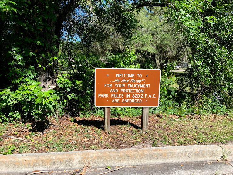 A retro, coffee brown trail sign greets bikers at the end